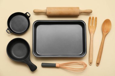 Bej arka planda mutfak gereçleri olan yemek tepsisi. Üst görünüm