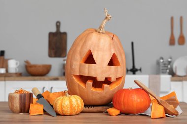 Cadılar Bayramı balkabağını bıçakla oydum ve tezgahın üzerine bir kase tohum koydum.