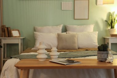 Rahat yatak, komodin, yatak odasının içinde dergi ve dekor.