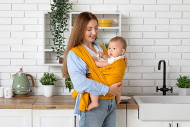 Evde küçük bir bebeği olan genç bir anne.