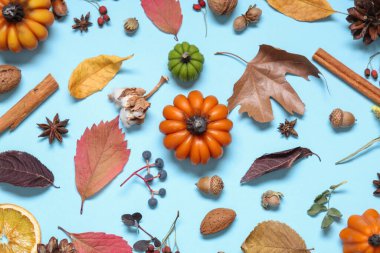 Balkabağı şeklinde mumlar, sonbahar yaprakları ve mavi arka planda böğürtlenler