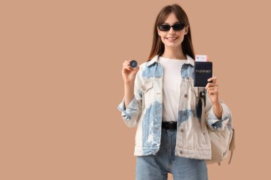 Bej arka planda pusula ve pasaportu olan kadın turist.