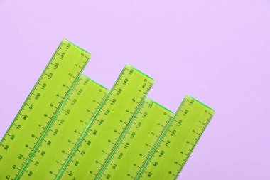 Mor arkaplanda yeşil plastik cetvel