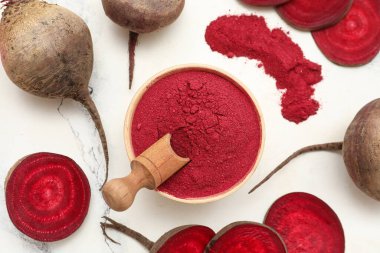 Tahta kase, kepçeli pancar tozu, taze pancar ve arka planda dilimler.