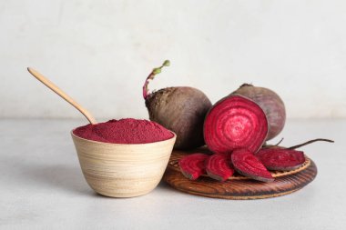 Tahta kase canlı pancar tozu ve beyaz arka planda taze pancar.