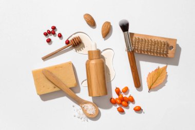 Temel yağ şişesi, doğal malzemeler ve hafif arka planda masaj fırçası bileşimi