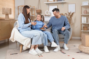 Mutlu aile ve kızları ellerinde bir tabak kurabiyeyle evdeki kanepede oturuyorlar.