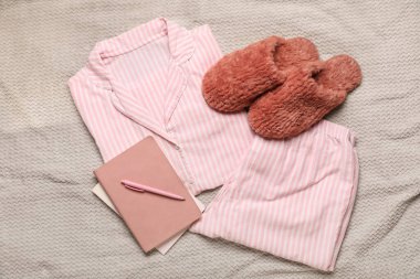 Yatağında defter olan şık pijamalar.