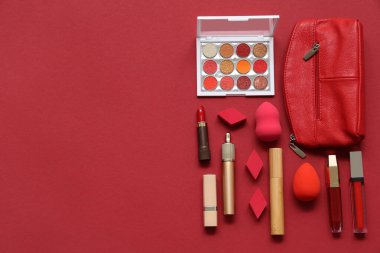 Kozmetik çanta, makyaj ürünleri ve aksesuarlar kırmızı arkaplanda