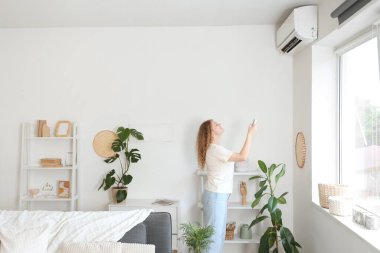Evinde klimalı, gülümseyen genç bir kadın.