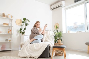 Evdeki klimayı açan güzel bir kadın.