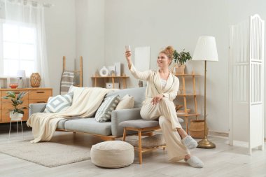 Evinde klimalı, gülümseyen genç bir kadın.