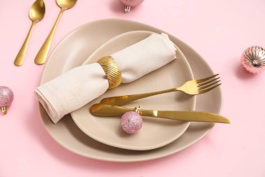 Pembe arka planda Noel topları olan güzel bir masa.