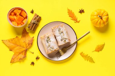 Lezzetli balkabaklı börek, tohumlar, tarçın, yıldız anason ve sarı arka planda sonbahar yaprakları.