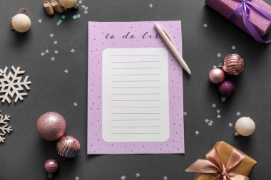 Hediyeli boş yapılacaklar listesi ve karanlık arka planda Noel dekoru