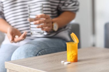 Oturma odasındaki masada ilaç şişesi. Yakın çekim.