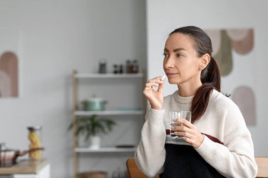 Evde hap alan güzel bir kadın.