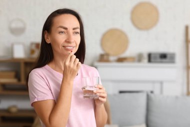 Evde ilaç alan güzel bir kadın.