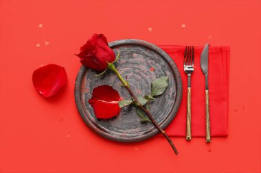 Kırmızı gül ve renk arkaplanlı taç yapraklarıyla çok güzel bir masa. Sevgililer Günü kutlaması