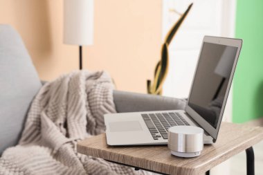 Kahve masasında kablosuz hoparlörü olan modern bir laptop. Yakın çekim.