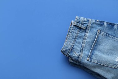 Mavi arka planda katlanmış kot pantolon