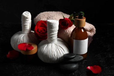 Kozmetik ürünleri, spa aksesuarları ve koyu arkaplanda gül çiçekleri olan bir kompozisyon. Sevgililer Günü kutlaması