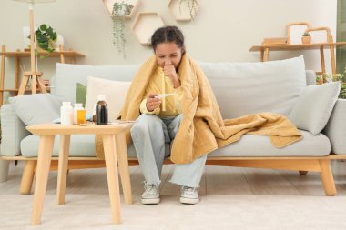 Hasta Afro-Amerikalı kız evde ateşi kontrol ediyor.