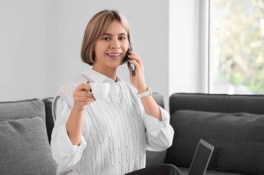 Ofiste cep telefonuyla konuşan başarılı bir iş kadını.