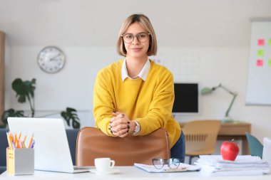 Modern ofiste gülümseyen başarılı iş kadını