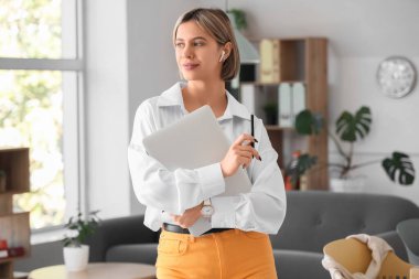 Ofisinde modern dizüstü bilgisayarı olan genç bir kadın