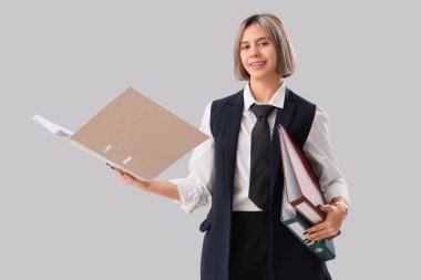 Başarılı iş kadını, beyaz arkaplandaki klasörlerde gazete okuyor