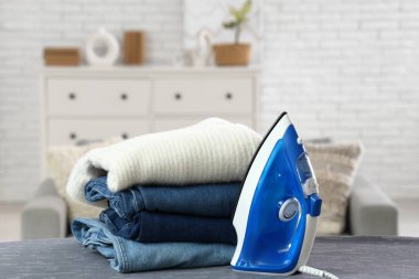 Temiz kıyafetler ve elektrikli ütü odada.