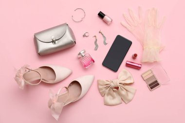 Yüksek topuklu kompozisyon, kozmetik ürünler ve pembe arka planda aksesuarlar. Üst görünüm