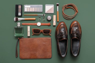 Kozmetik ürünleri, aksesuarlar, ayakkabılar ve debriyajlı yeşil arka plan. Üst görünüm