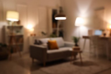 Konforlu kanepe, sehpa ve akşam oturma odasının iç tarafında iş yeri. Bulanık görünüm
