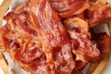 Beyaz arka planda kızarmış pastırmalı ahşap tabak, yakın plan.