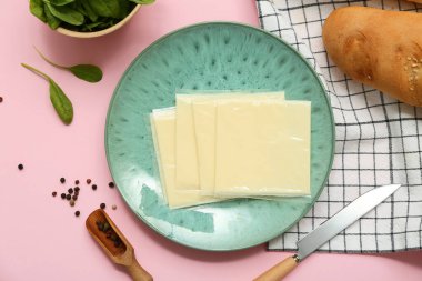 Pembe arka planda lezzetli işlenmiş peynir dilimleri. Üst görünüm