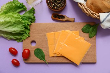 Lezzetli işlenmiş peynir ve arkaplanda sebze dilimleri olan bir pano. Üst görünüm
