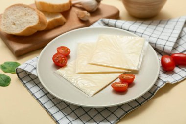 Lezzetli işlenmiş peynir, domates ve bej arka planda ıspanak dilimli peçete. Yakın çekim.