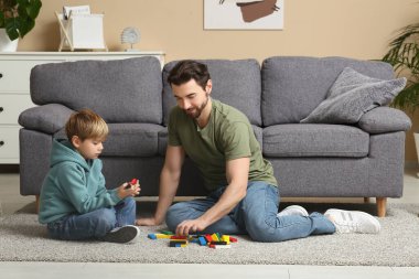 Baba ve küçük oğlu evde renkli bloklarla oynuyorlar. Babalar Günü.