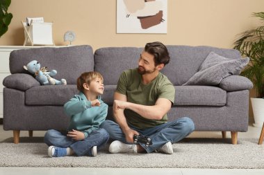 Baba ve küçük oğlu evde yumruk tokuşturuyorlar. Babalar Günü.