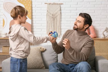 Sevimli küçük oğlu babasına hediye veriyor. Babalar Günü.