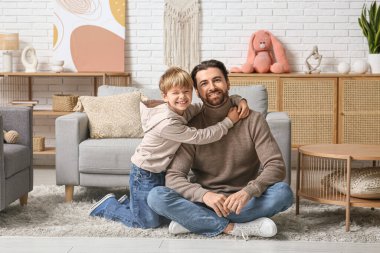 Evde babasına sarılan sevimli küçük bir oğlan. Babalar Günü.