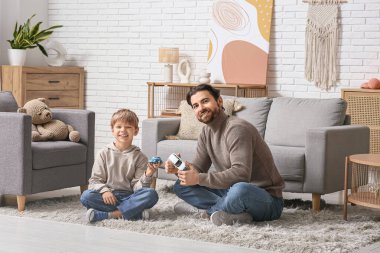 Babası ve küçük oğlu evde oyuncak arabalarla oynuyorlar. Babalar Günü.