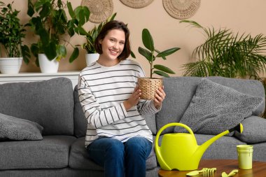 Oturma odasındaki kanepede oturan sulu tenekeli güzel kadın