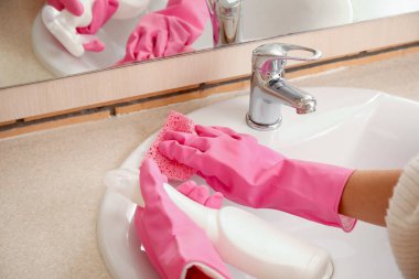 Banyoda küf temizleyen paçavralı bir kadın, yakın plan.