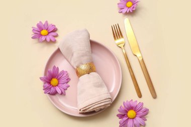 Bej arka planda güzel kasımpatı çiçekleri olan şık masa ayarı