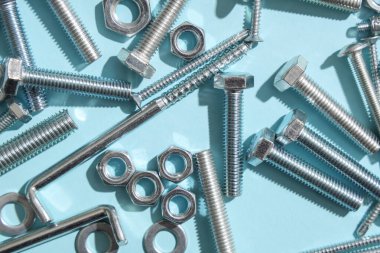 Mavi arka planda farklı tap cıvataları ve krom fındıklar