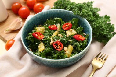 Bir kase lezzetli lahana salatası, yanında kırmızı biber ve portakal.