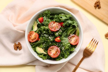 Sebzeli bir kase lezzetli lahana salatası, susam tohumu ve renkli peçete.